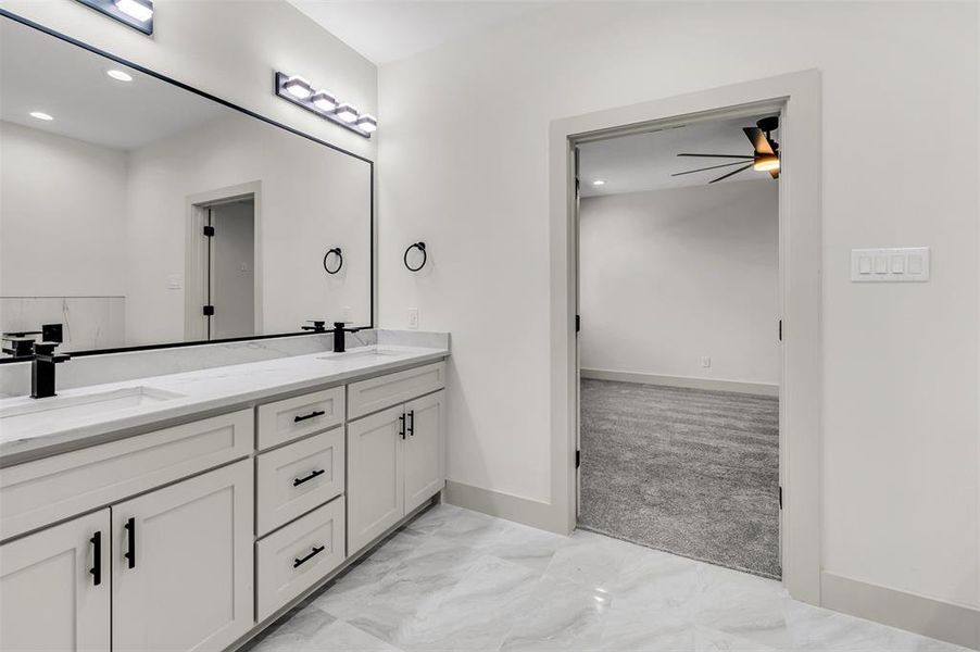 Bathroom featuring double vanity, recessed lighting, light marble finish floors, and ceiling fan