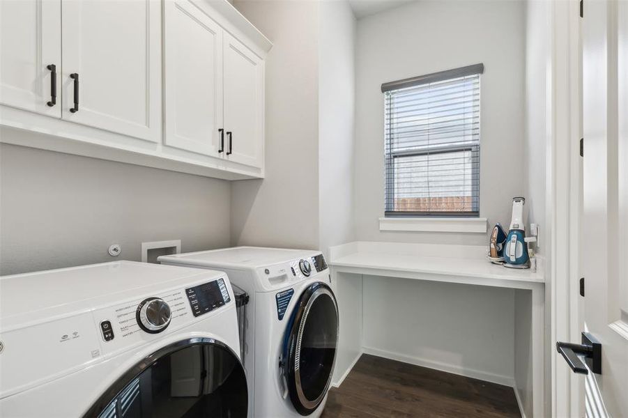 Washroom with separate washer and dryer, cabinets, and dark hardwood / wood-style floors