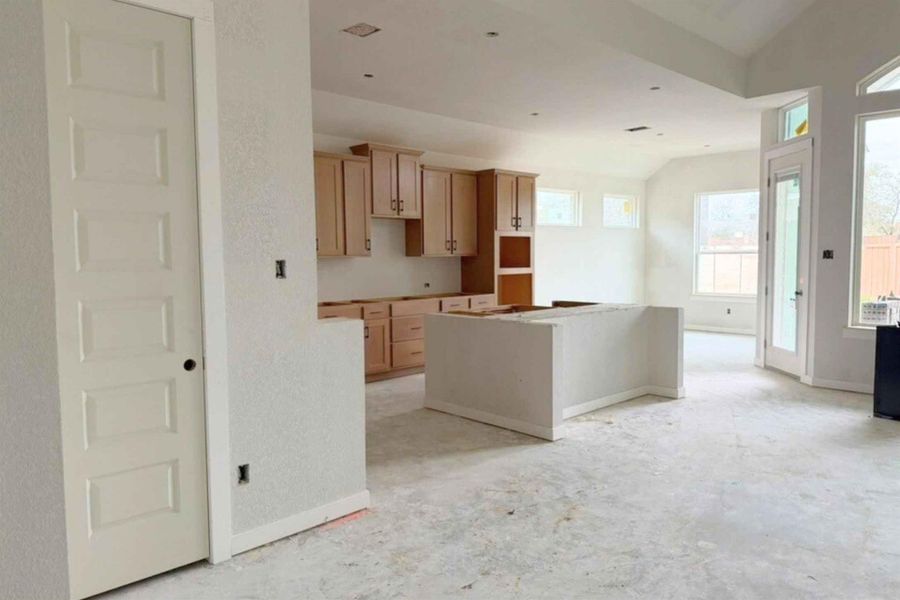 Kitchen featuring light wood finish cabinetry, vaulted ceiling, and a center island