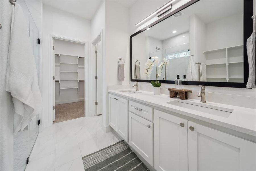 Primary Bathroom with double vanity and a shower with shower door