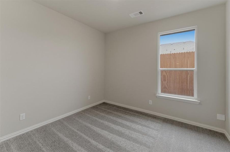 Neutral-toned interior room featuring light gray walls, gray patterned carpet, and white baseboards