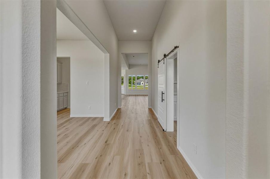 Long hallway featuring wood-finish flooring and recessed lighting Long hallway featuring wood-finish flooring and recessed lighting