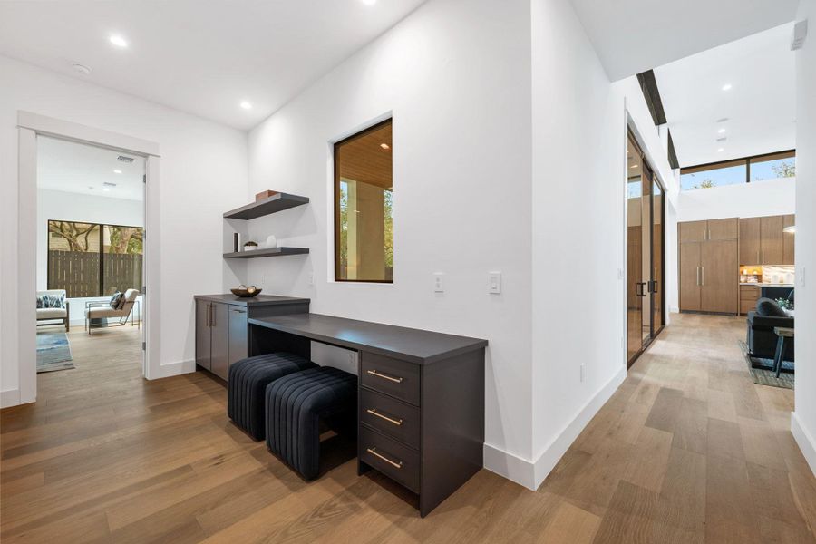 Corridor featuring a desk, light wood-type flooring, and recessed lighting
