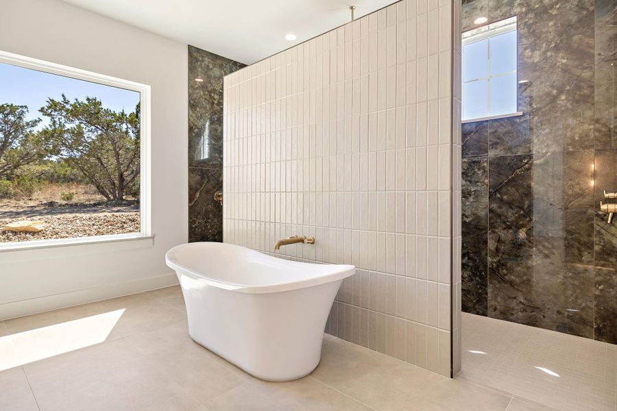 Full bathroom featuring a freestanding tub, tile patterned flooring, a walk in shower, and tile walls