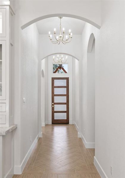 Foyer featuring a chandelier and arched walkways