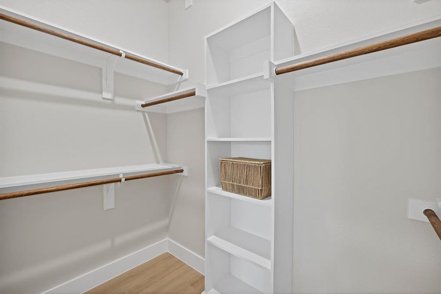 Walk in closet featuring wood finished floors Walk in closet featuring wood finished floors