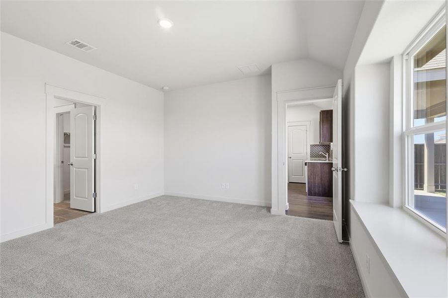 Unfurnished bedroom featuring light carpet, vaulted ceiling, and recessed lighting