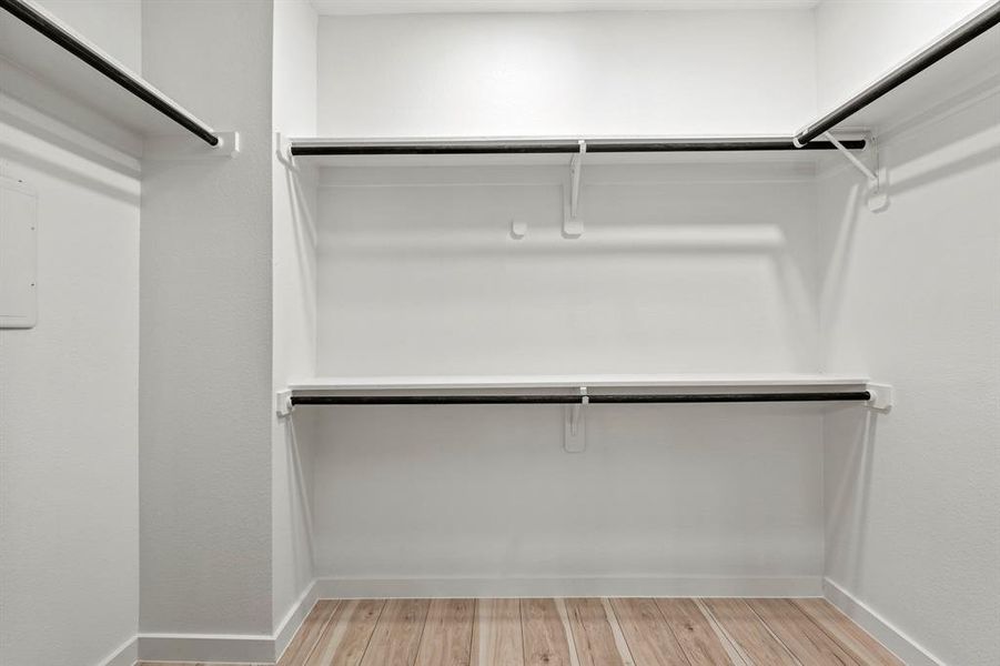 Walk in closet with light wood-style floors Walk in closet with light wood-style floors