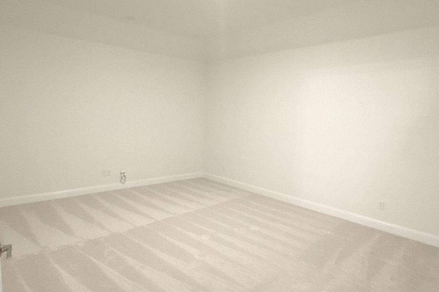 Unfurnished room featuring baseboards and light carpet