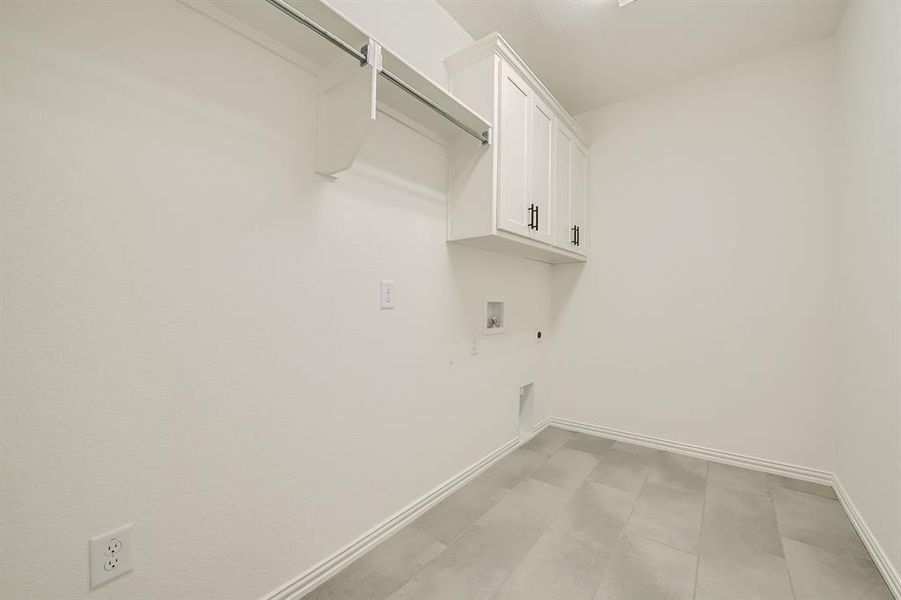 Laundry area featuring hookup for a gas dryer, electric dryer hookup, washer hookup, and cabinets