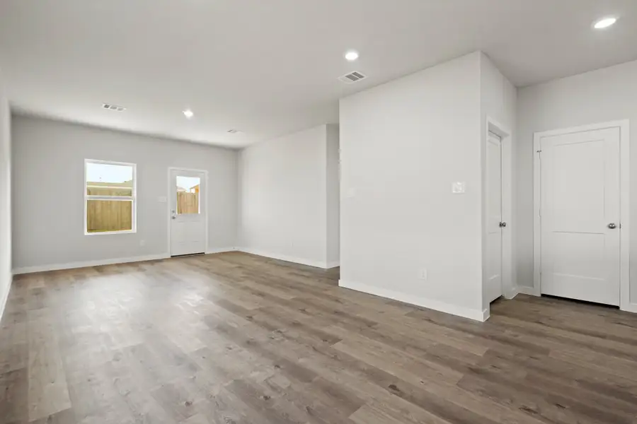 A room with white walls and wood floors.