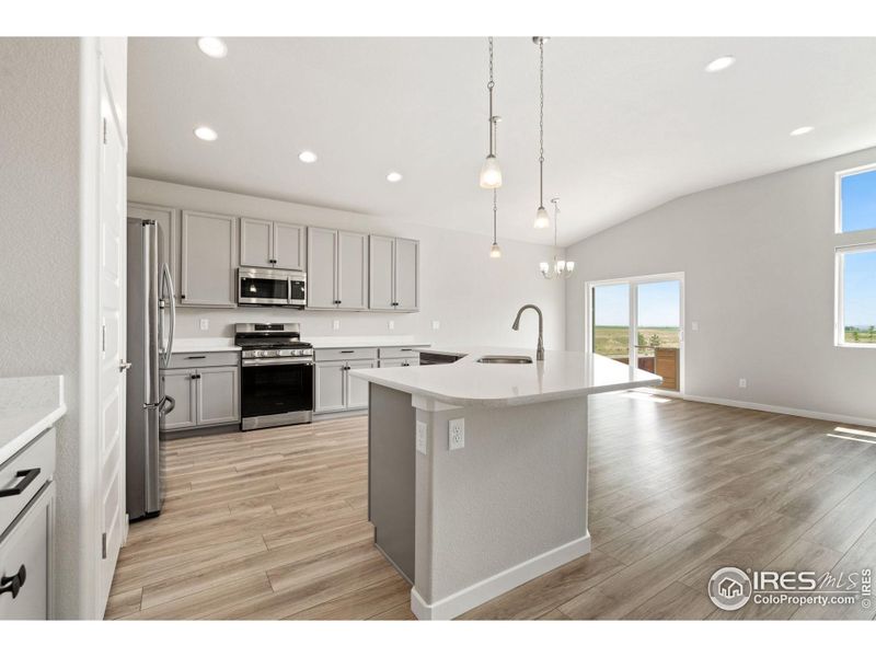 Large kitchen with lots of cabinets and quartz counters