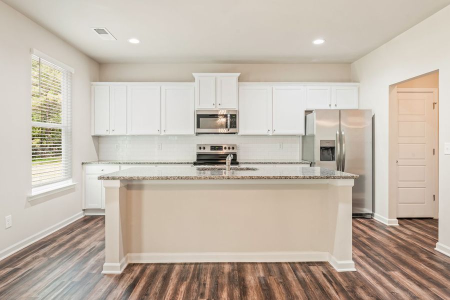 The kitchen with a center island overlooks the breakfast area and family room