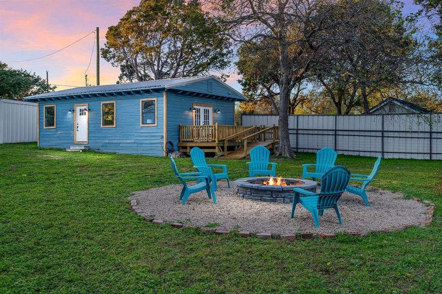 Improved graveled fire pit area with Adirondacks makes for a lovely space to gather. Oh, and that's the DARLING guest cottage!