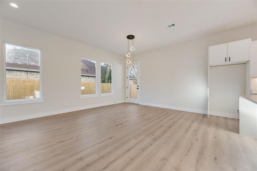 Unfurnished living room featuring light wood-type flooring and baseboards Unfurnished living room featuring light wood-type flooring and baseboards