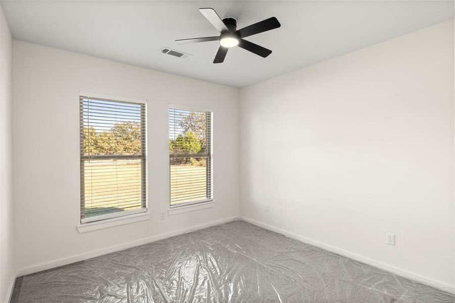 Carpeted empty room with baseboards and ceiling fan