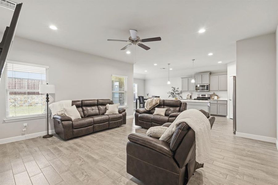 Open-concept living space featuring wood-finish flooring, recessed lighting, and a ceiling fan Open-concept living space featuring wood-finish flooring, recessed lighting, and a ceiling fan