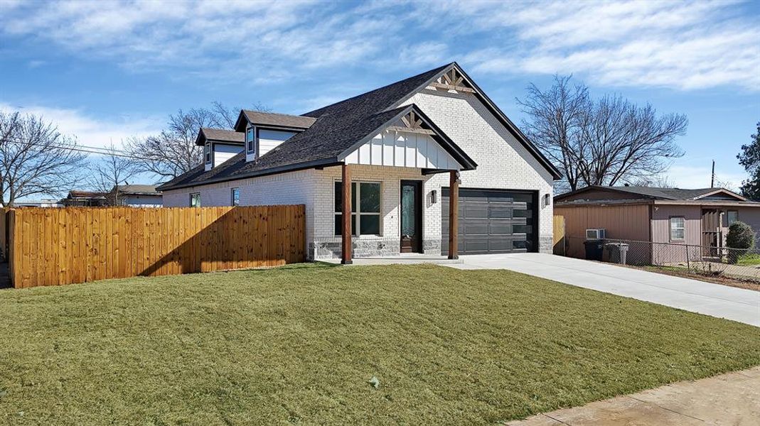 Modern inspired farmhouse featuring brick siding and driveway