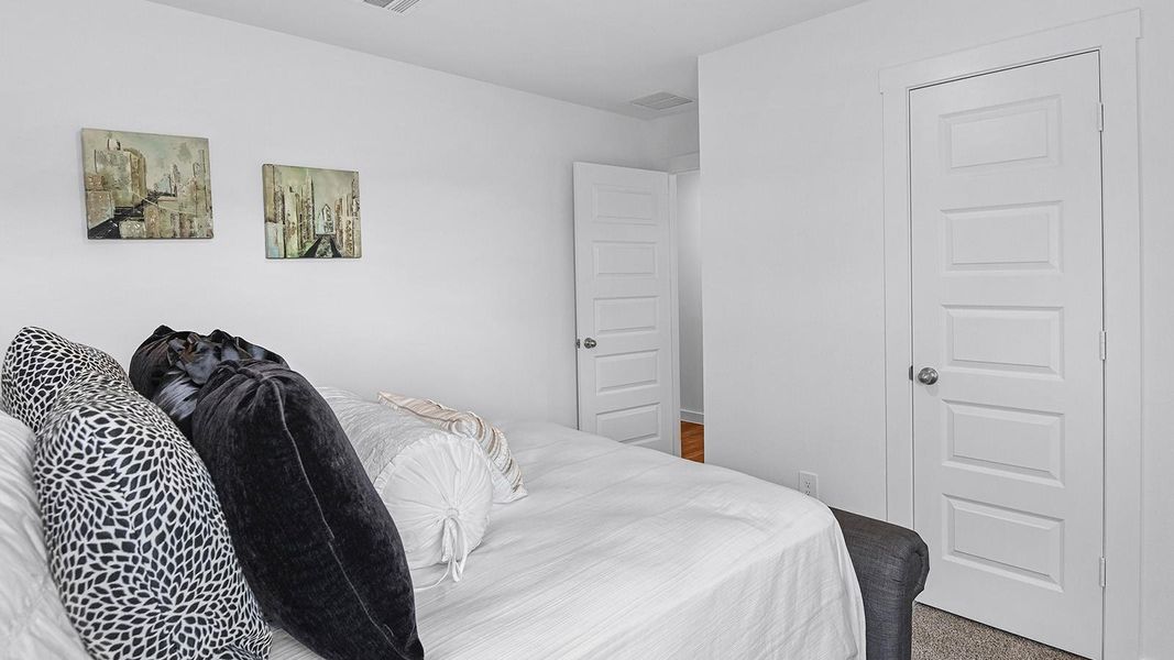 A third bedroom with neutral walls, plush carpet flooring and a separate closet.