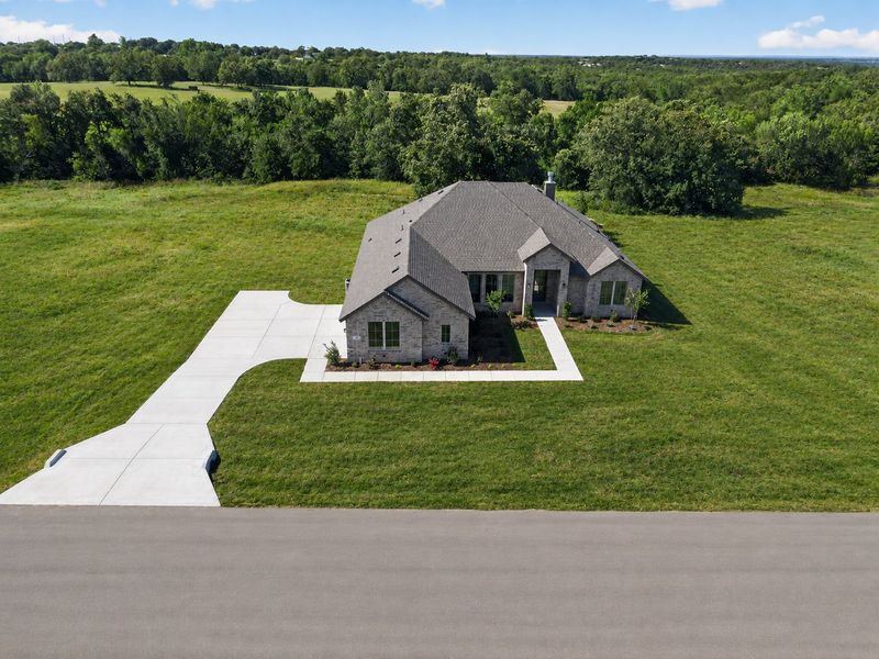 Front exterior of a new home in Terra Vista Estates, Springtown, TX, highlighting curb appeal (Image 2). Front exterior of a new home in Terra Vista Estates, Springtown, TX, highlighting curb appeal (Image 2).