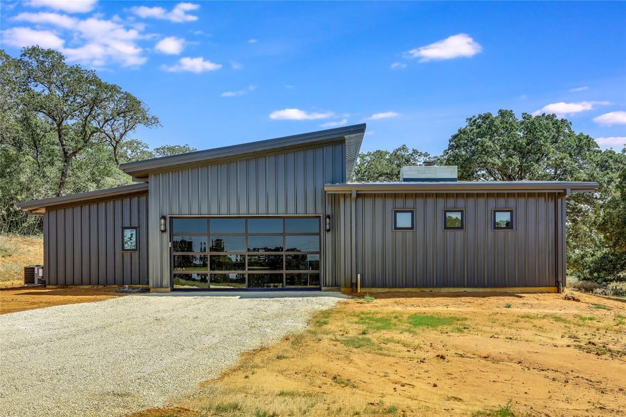 View of outbuilding with a garage and gravel driveway
