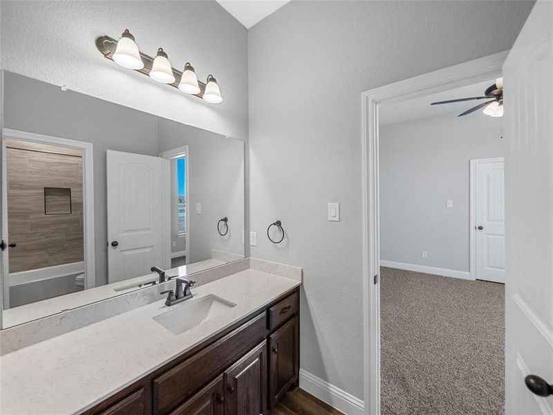 Prior listing photo. Property remains accurate - Full bath featuring ceiling fan, vanity, and dark colored carpet