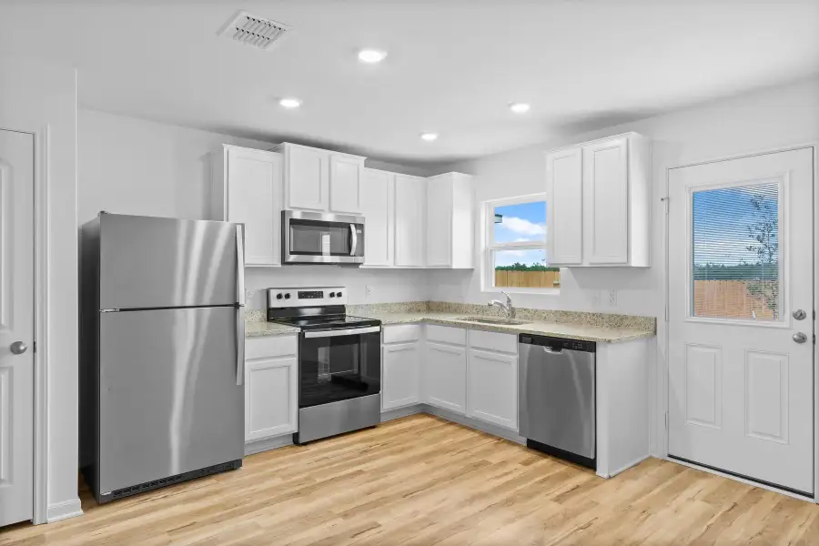 Kitchen featuring stainless steel appliances, light wood-type flooring, white cabinets, light stone counters, and recessed lighting