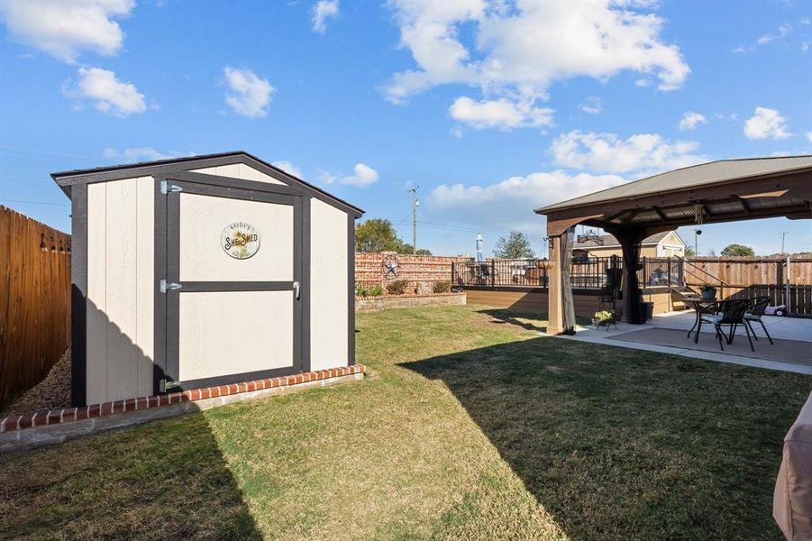 View of yard featuring a gazebo, a storage shed, and a patio area