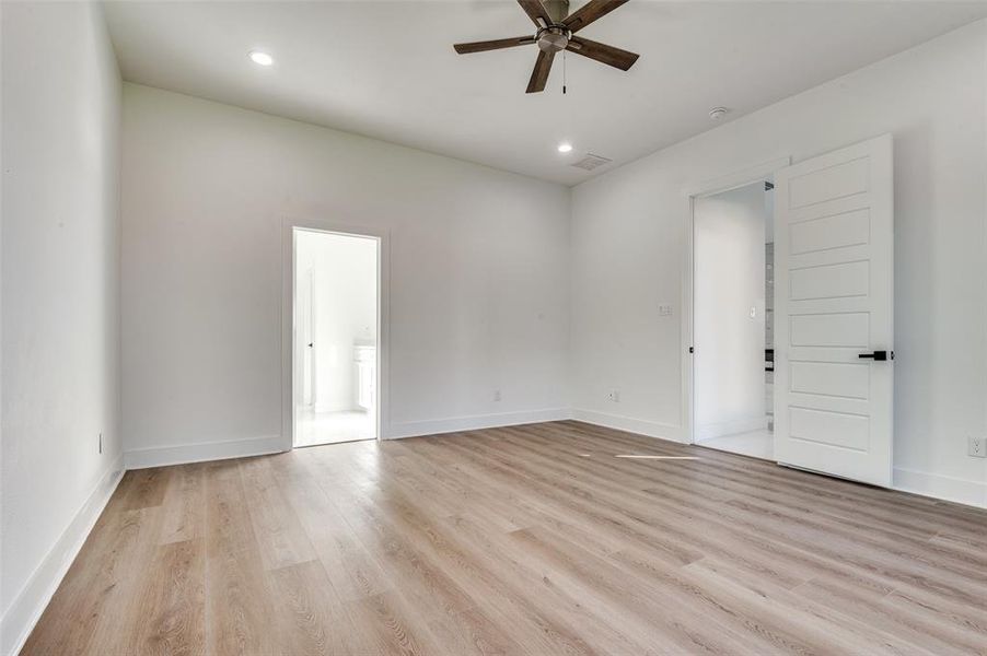 Empty room featuring light wood-style flooring, ceiling fan, and recessed lighting