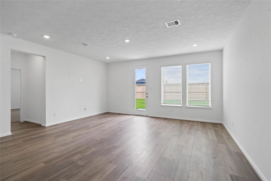 Bring family and friends together in this beautiful Great Room! It features high ceilings, recessed lighting, custom paint, vinyl plank flooring, and large windows that fill the space with natural light all day long.