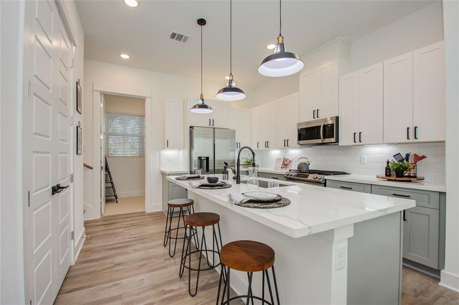 This attractive Kitchen is full of beautiful details. Quartz Countertops, Stainless Sink, Stainless Steel Appliances, Recessed Lighting and pendant lights, Undercabinet Lighting, Elegant Cabinetry with Soft Close Drawers and Doors. UNDER CONSTRUCTION!!  Photos from another community's model home FINISHES & COLORS MAY VARY! Ceiling fans are not included!