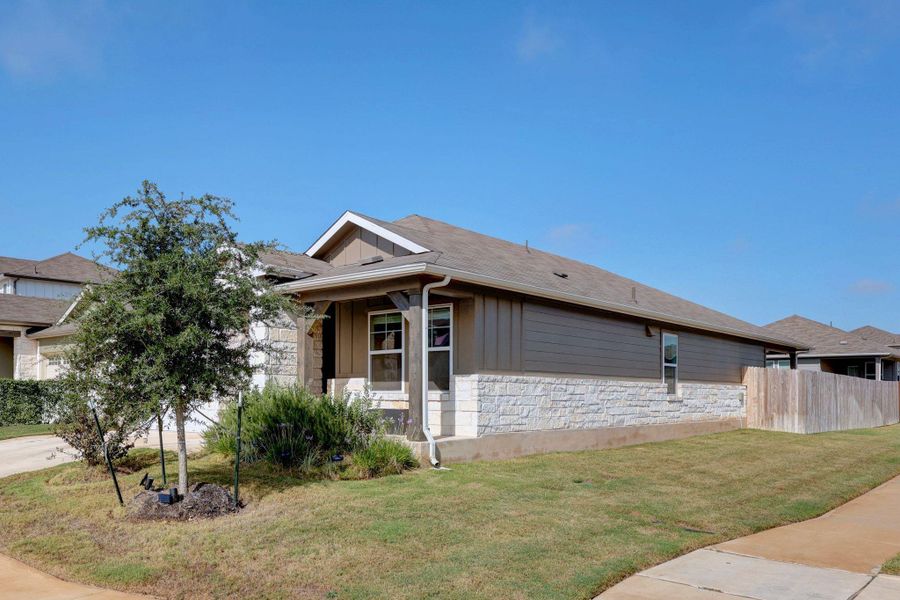 View of property exterior with stone siding, board and batten siding, a porch, and a shingled roof View of property exterior with stone siding, board and batten siding, a porch, and a shingled roof