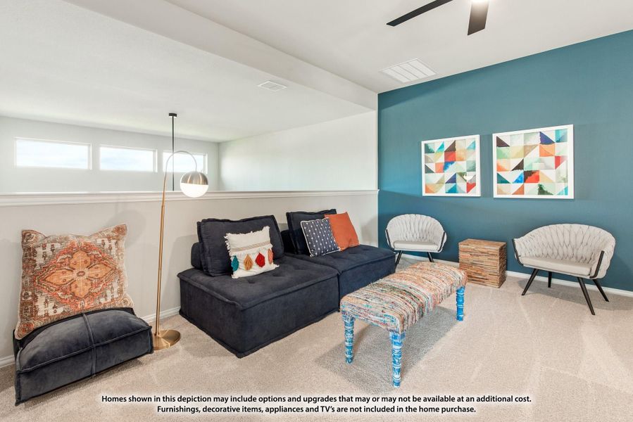 Living room with dark sectional sofa, teal accent wall, and carpet flooring with ceiling fan above