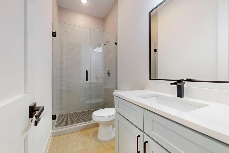 Bathroom with a stall shower, vanity, light wood-type flooring, and recessed lighting