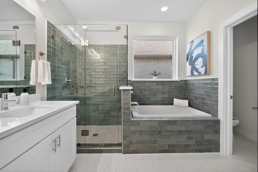 Full bath with vanity, a bath, a stall shower, and light tile patterned floors Full bath with vanity, a bath, a stall shower, and light tile patterned floors