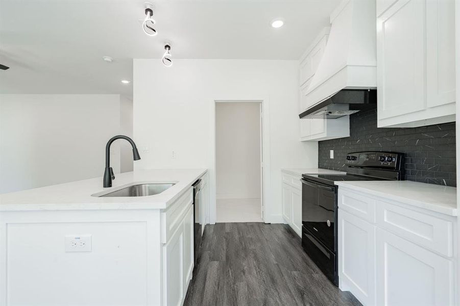 Kitchen with white cabinetry, dark hardwood / wood-style floors, black electric range oven, and sink