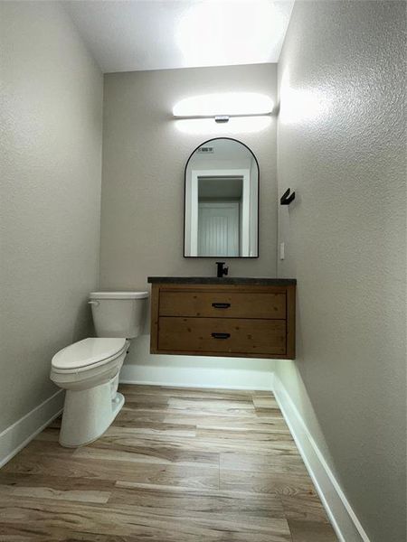 Bathroom with vanity, toilet, and wood-type flooring