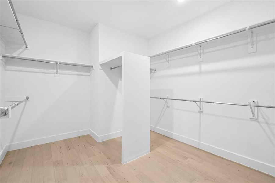 Spacious closet with light wood-type flooring Spacious closet with light wood-type flooring