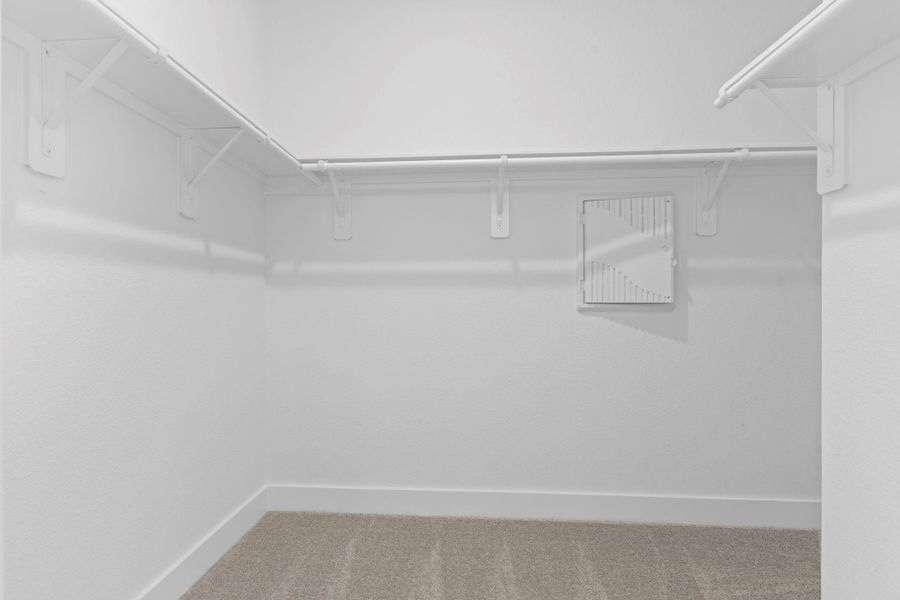 The expansive walk-in closet offers generous storage with built-in shelving and plush carpet underfoot, creating the perfect blend of form and function for your wardrobe dreams. **Image Representative of Plan Only and May Vary as Built**.