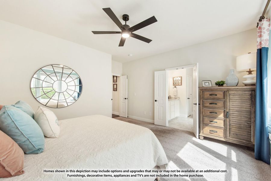 Bedroom with ceiling fan, carpet flooring, dresser, and open door to ensuite bathroom