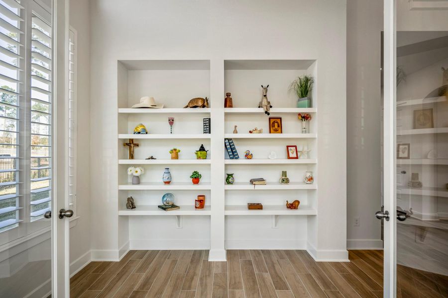 Just off the entry are these built-in shelves for display and storage, with a glass door leading to an adjoining office.