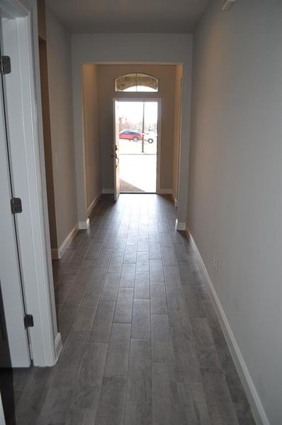 Hallway with dark hardwood / wood-style flooring