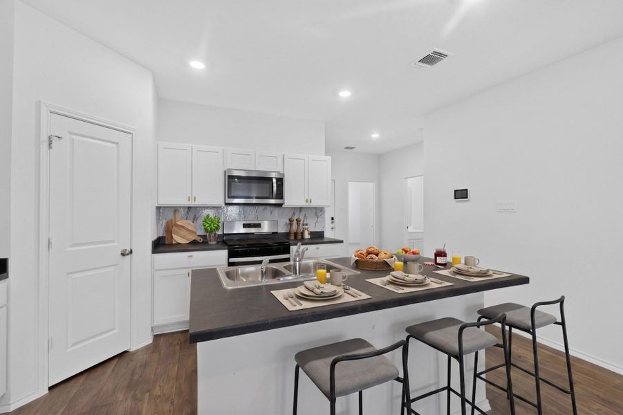 Gleaming hardwood floors and a spacious center island anchor this beautifully appointed modern kitchen. Gleaming hardwood floors and a spacious center island anchor this beautifully appointed modern kitchen.