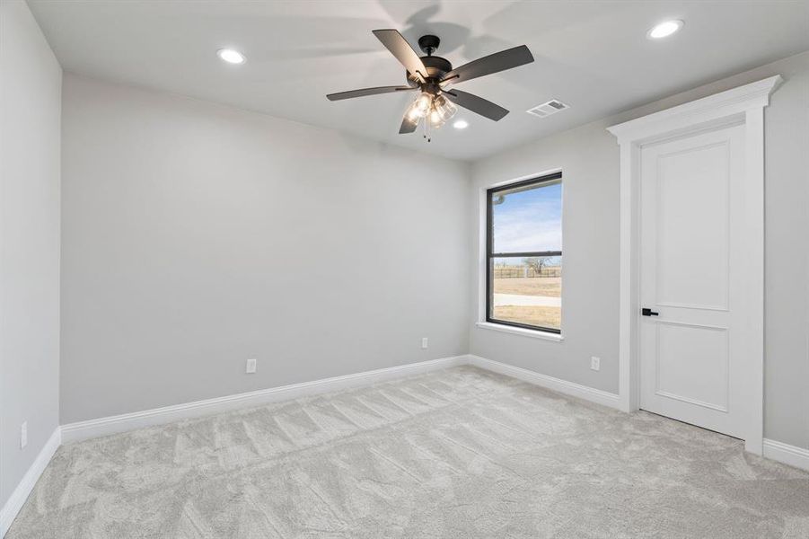 Carpeted spare room with ceiling fan