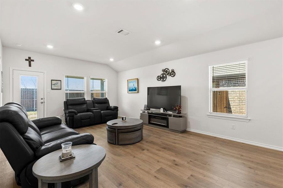 Living area with vaulted ceiling, light wood-style floors, and recessed lighting Living area with vaulted ceiling, light wood-style floors, and recessed lighting