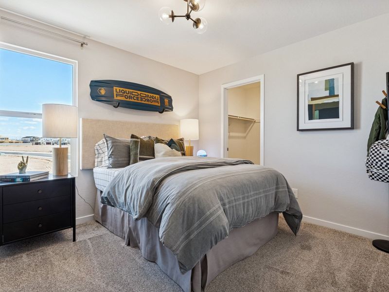 A bedroom with a bed and a desk.