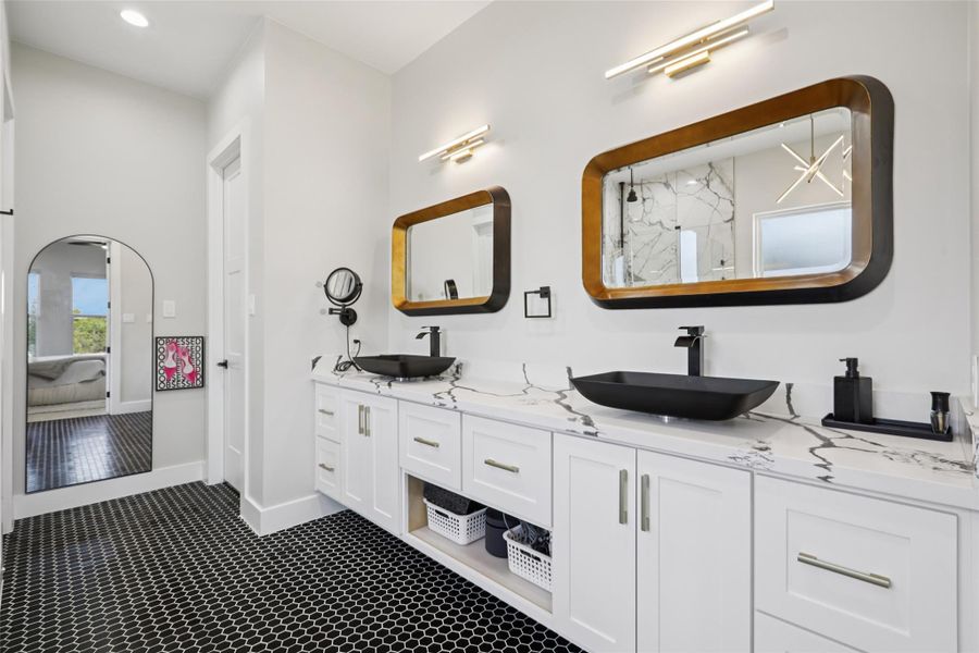 Ensuite bathroom featuring double vanity, a marble finish shower, and recessed lighting