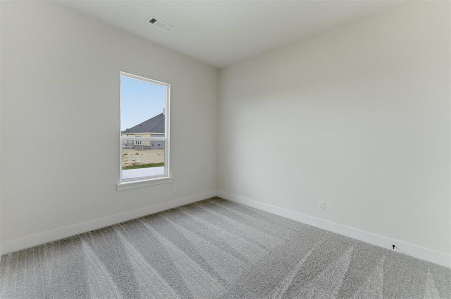 Room featuring light gray walls, white trim, a single window with white framing, and gray patterned carpet