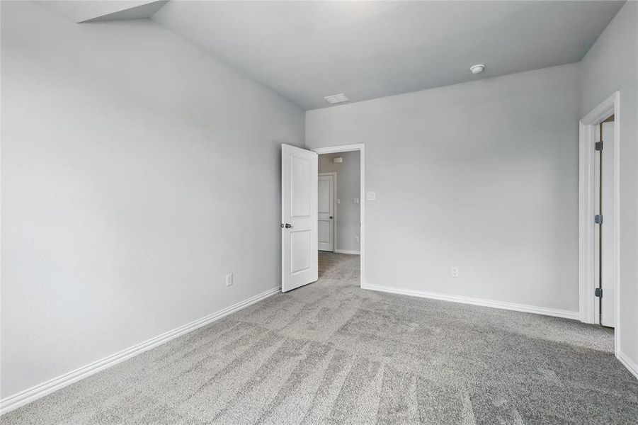 Unfurnished bedroom with light carpet and baseboards