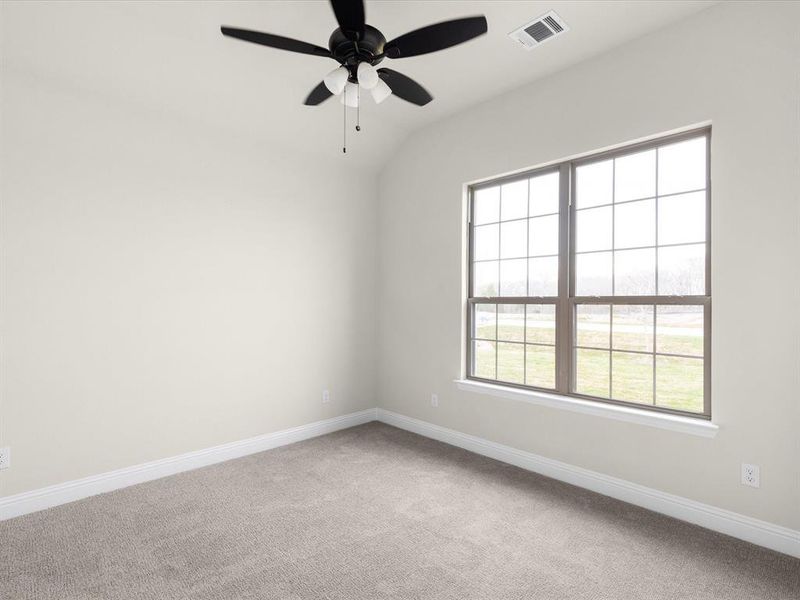 Empty room featuring a ceiling fan, light carpet, and lofted ceiling